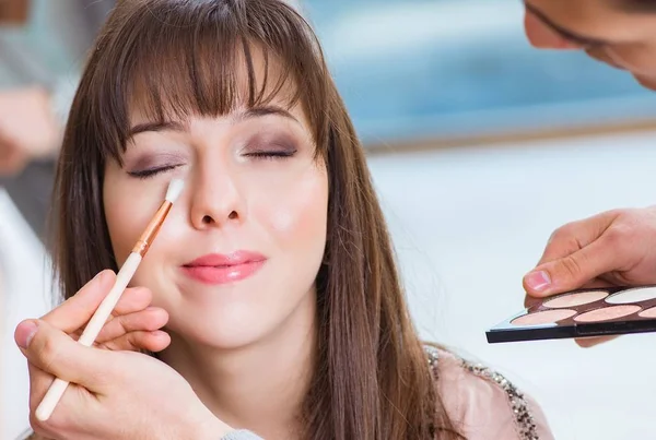 Uomo che fa il make-up per la donna carina nel salone di bellezza — Foto Stock