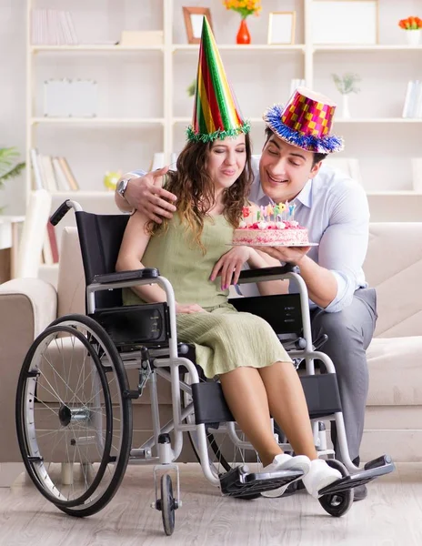 Joven familia celebrando cumpleaños con persona discapacitada —  Fotos de Stock