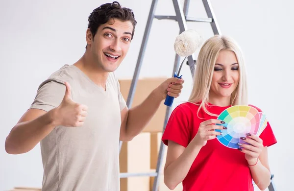 Молодая семья, занимающаяся живописью во время ремонта дома — стоковое фото