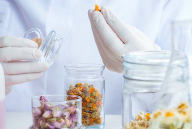 Laboratuvarda parfüm karıştıran bir kimyager.