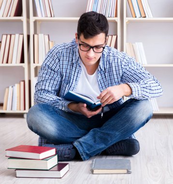 Genç öğrenci kitaplarla çalışıyor.