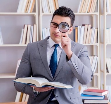 Büyüteçle hukuk fakültesi öğrencisi kitap okuyor.