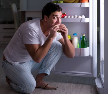 Buzdolabındaki adam gece yemek yiyor.