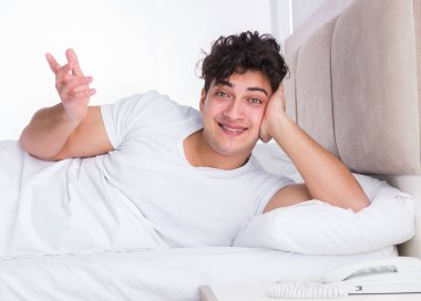 Yatakta uykusuzluk çeken bir adam.