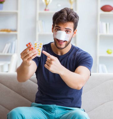 Genç adam estetik cerrahi burnundan sonra evde iyileşiyor.