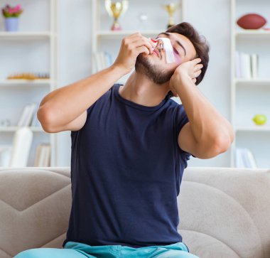 Genç adam estetik cerrahi burnundan sonra evde iyileşiyor.