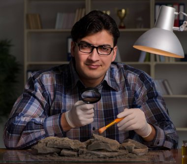 Arkeolog geç saatlere kadar ofiste çalışıyor.