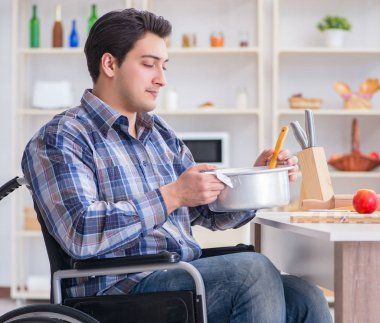 Engelli adam mutfakta çorba hazırlıyor.