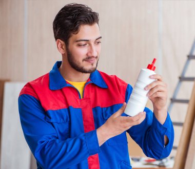 Yooung marangoz boyayla uğraşıyor.