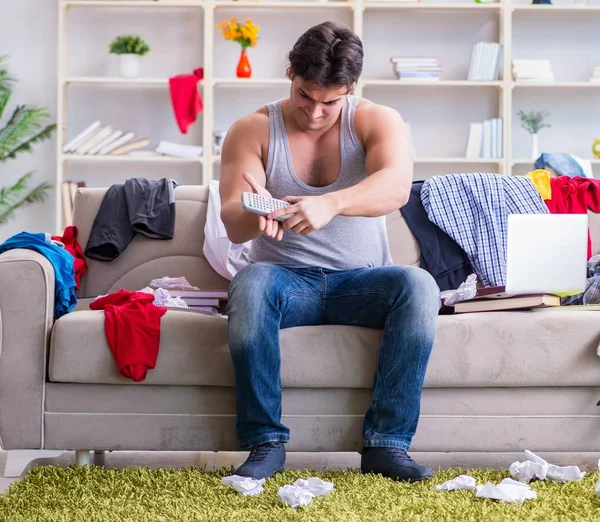 Jongeman aan het werk in rommelige kamer — Stockfoto