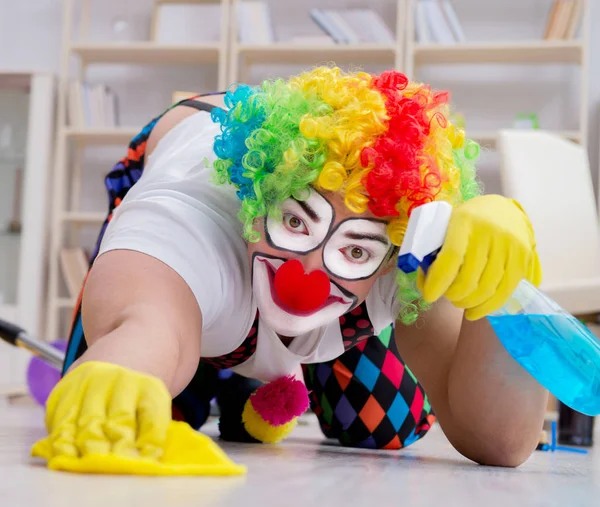 Funny clown doing cleaning at home