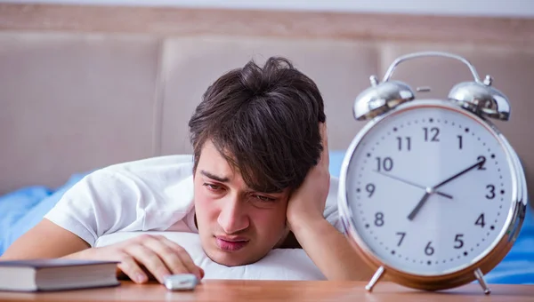 Homem na cama frustrado sofrendo de insônia com um coágulo de alarme — Fotografia de Stock