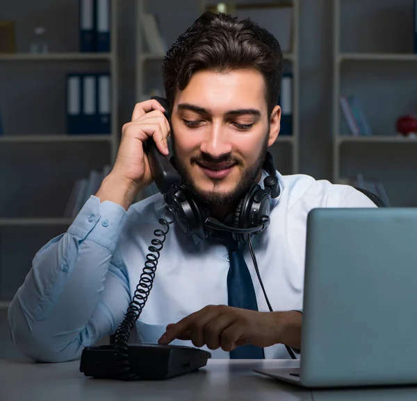 Jongeman in call center concept werken laat overuren in het kantoor — Stockfoto