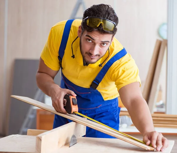 Ung reparatör snickare arbetar skärande trä på cirkulär såg — Stockfoto