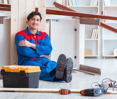 Genç marangoz ahşap kalaslarla çalışmaya ara veriyor.