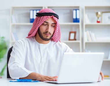 Ofiste çalışan Arap işadamı bir Pi ile evrak işi yapıyor.