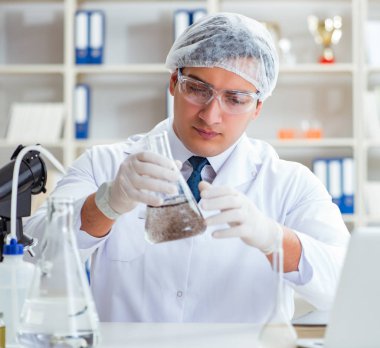 Genç araştırmacı bilim adamı bir su testi kirliliği araştırması yapıyor.