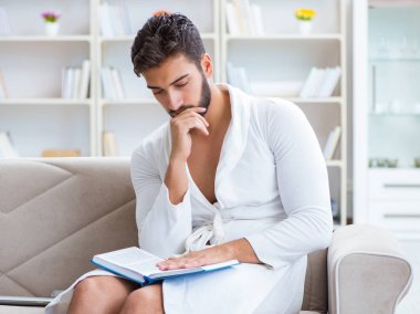 Öğrenci işadamı genç adam bir kitap okuyor.