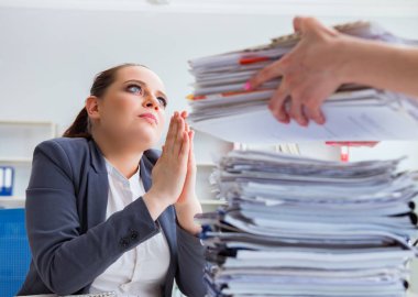 Evrak işleriyle uğraşan yorgun bir iş kadını.