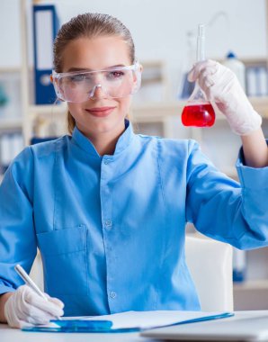 Bir laboratuarda deney yapan kadın bir bilim adamı.