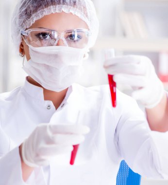 Bir laboratuarda deney yapan kadın bir bilim adamı.