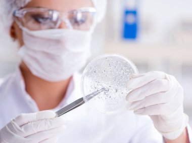 Bir laboratuarda deney yapan kadın bir bilim adamı.