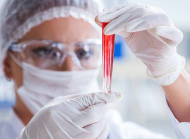 Bir laboratuarda deney yapan kadın bir bilim adamı.