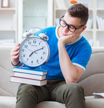 Sınavlara hazırlanan genç öğrenci kanepede ders çalışıyor.