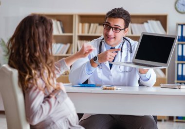 Hamile kadın muayene için doktoru ziyaret ediyor.