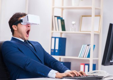 Çalışan ofiste sanal gerçeklik gözlüğü kullanıyor.