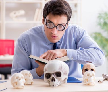 Komik çılgın profesör insan iskeletini inceliyor.