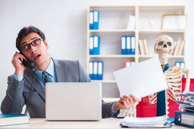 İskeletle çalışan bir iş adamı.