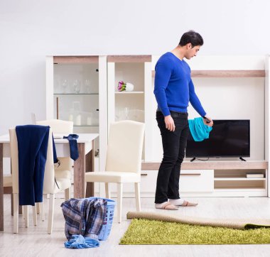 Genç adam çamaşırhane için kirli çamaşır topluyor.