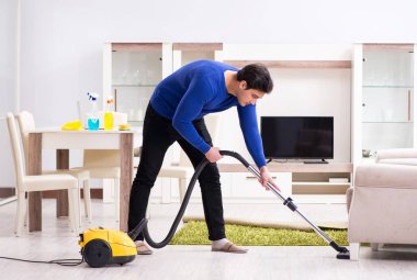 Genç adam evini temizliyor.