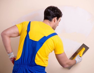 Duvara alçı yapıştıran genç müteahhit.