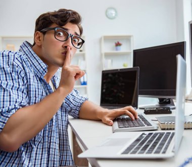 Birçok ekranın önünde oturan bir iş adamı