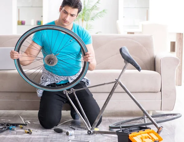 Jongeman die thuis een fiets repareert — Stockfoto