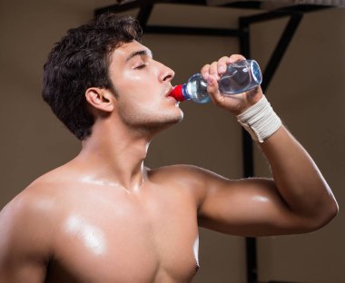 Spor salonunda su içen susamış bir adam.