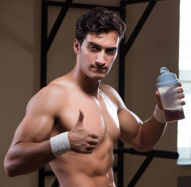 Spor salonunda besin takviyesi olan bir adam.