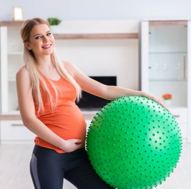 Evde doğum egzersizi yapmaya hazırlanan genç bir kadın.