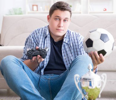 Genç adam evde bilgisayar oyunu oynuyor.