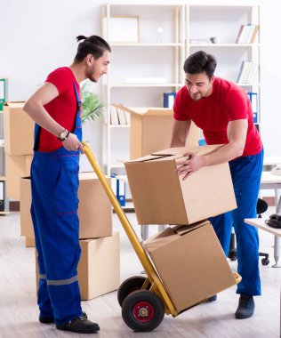 İki müteahhit personel kişisel eşyalarını taşıyor.