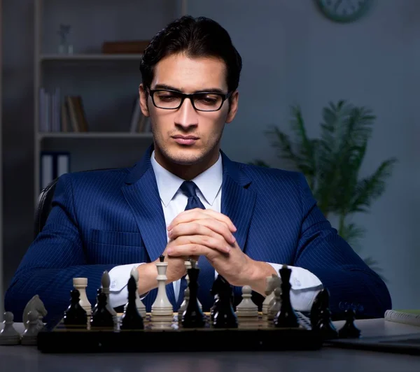 Businessman playing chess in strategy concept — Stock Photo, Image