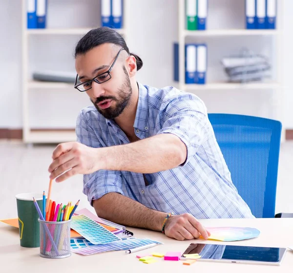 Joven diseñador trabajando en su estudio en un nuevo proyecto — Foto de Stock