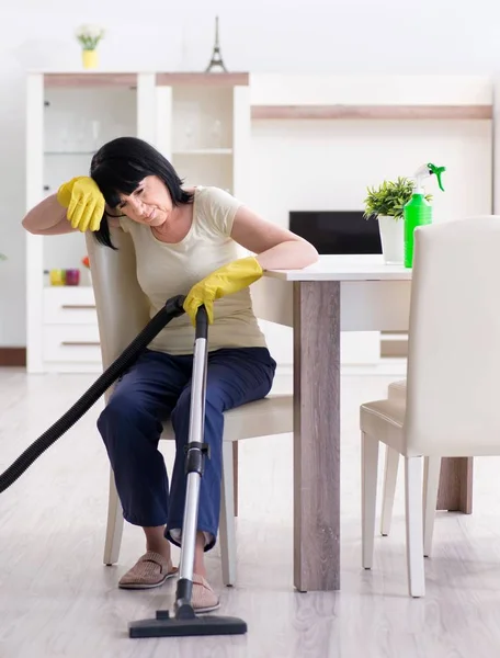 Senior old woman tired after vacuum cleaning house — Stock Photo, Image