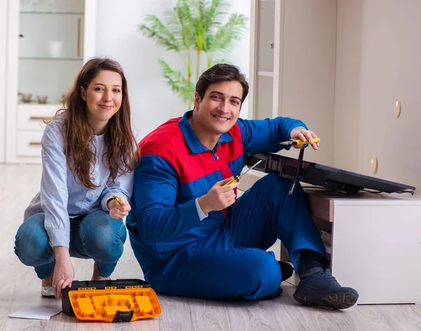 Repairman repairing tv at home