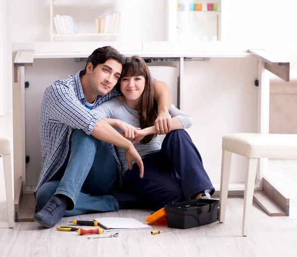 Erkek ve kadın evde mobilya montajı yapıyor.