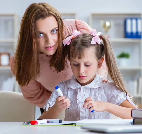 Mãe ajudando sua filha a fazer lição de casa — Fotografia de Stock