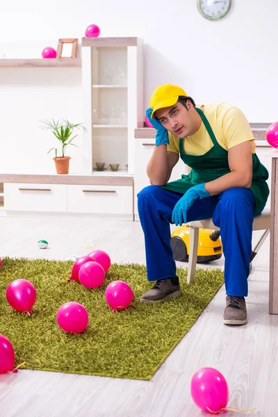 Jonge mannelijke aannemer doet huishoudelijk werk na partij — Stockfoto