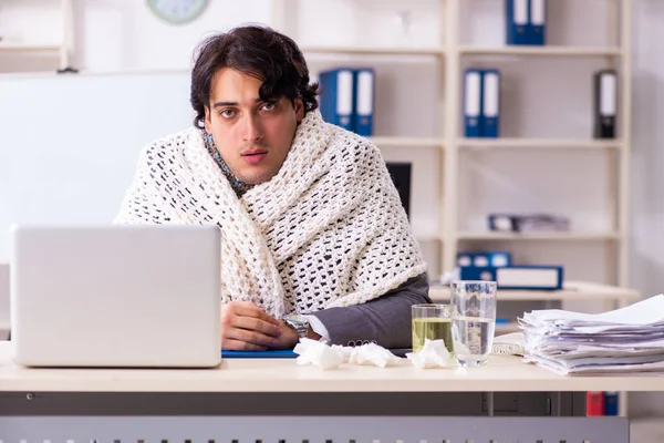 Человек с гриппом работает в офисе — стоковое фото